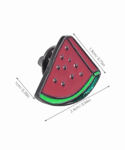 A watermelon slice-shaped enamel pin with black outlines, red interior, green rind, and small black seeds. Dimensions are indicated with arrows.