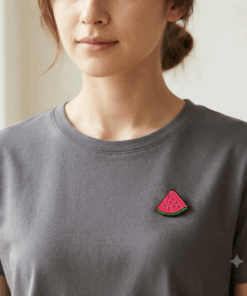 A Watermelon Slice Pin Badge worn on a female model on a short sleeve grey shirt