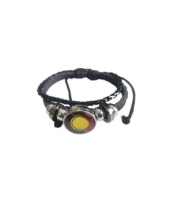 Black braided cord bracelet with a round metallic pendant featuring a yellow center and red accents, secured with small silver-toned beads and a small chain detail.